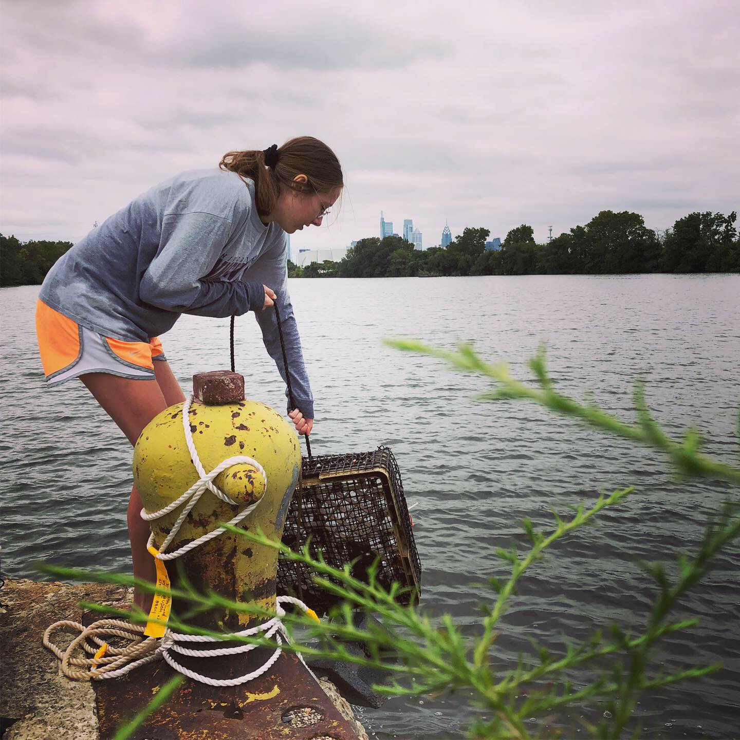  Penn Biology student, Izzy Viney, retrieves mussels from the Schuylkill River at our Bartram’s Garden research and community outreach site on S. 56th street.