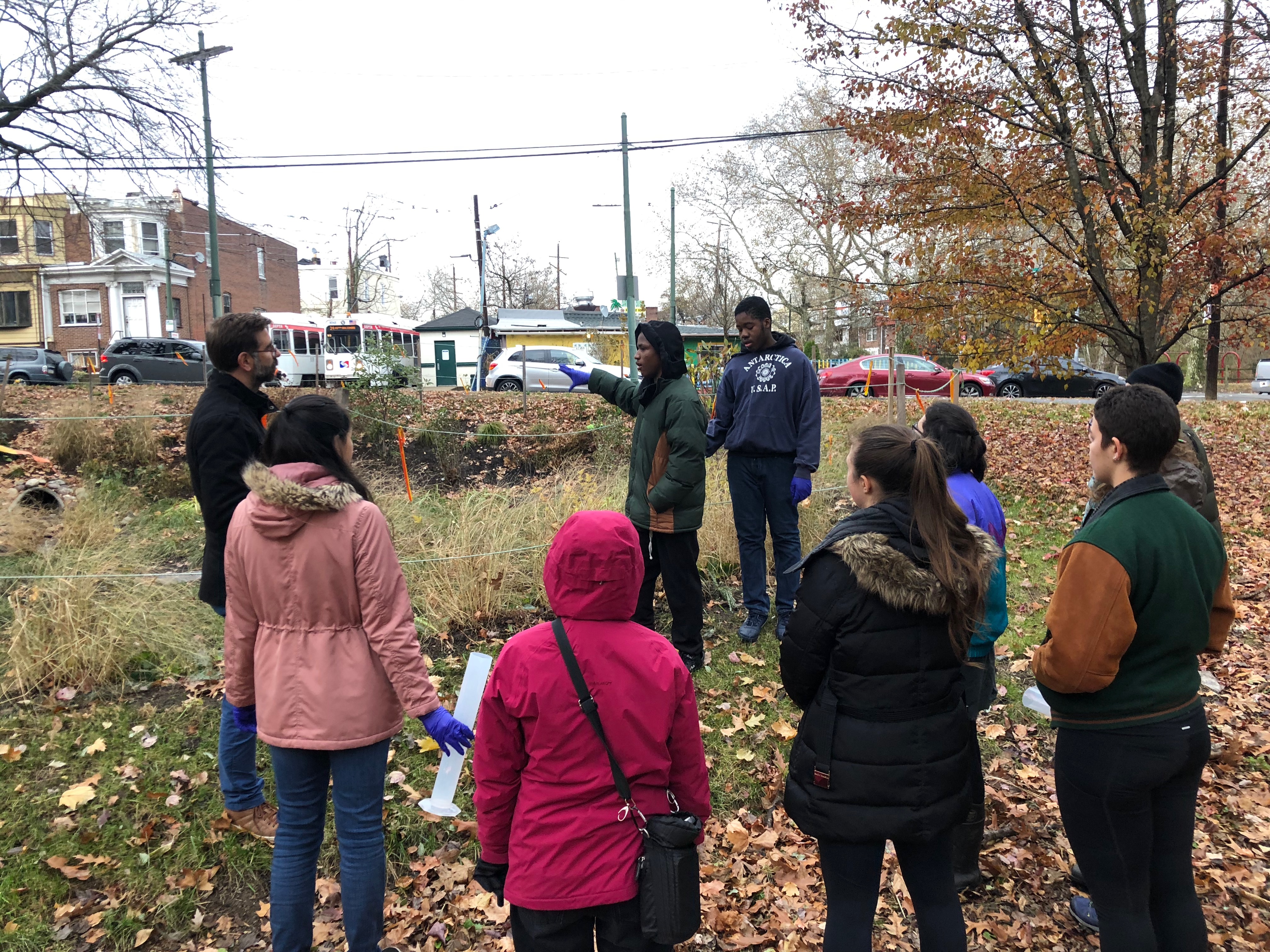 Two PWD Watershed Stewards explain the importance and function of a new rain garden on 63rd street to Penn undergraduate students. 